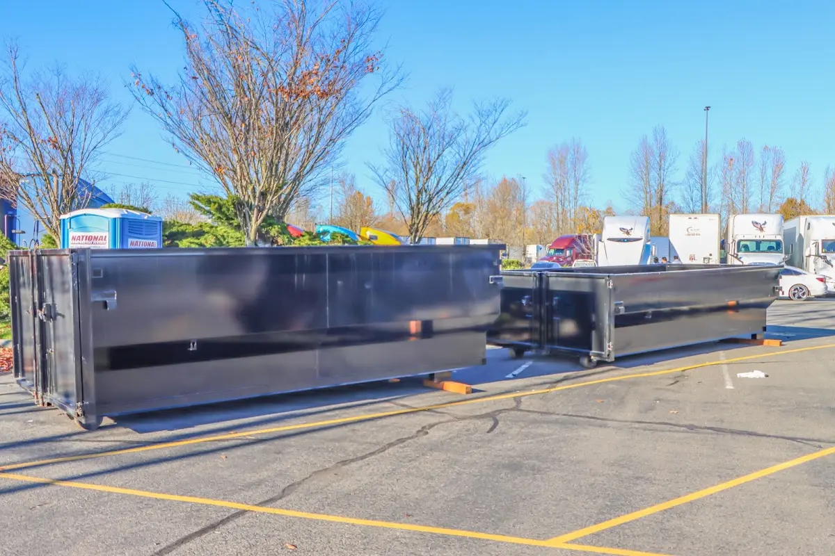 Professional dumpster rental service with roll-off container on residential driveway in Lake Mills